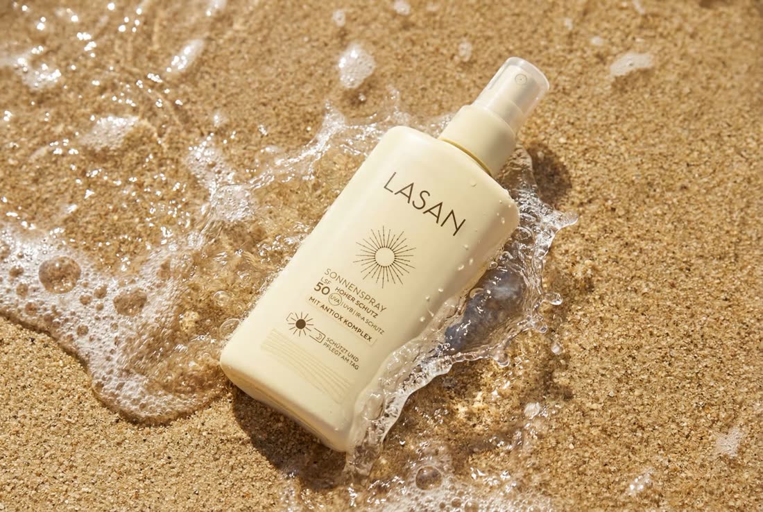 Lasan SPF 50 sun spray in surf on sand